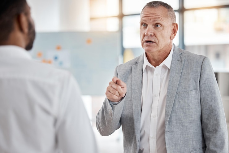 Two people talking in an office while one gestures to explain a point